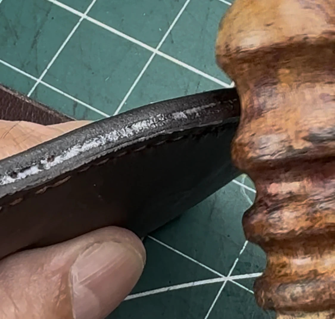 A leather edge being finished by hand